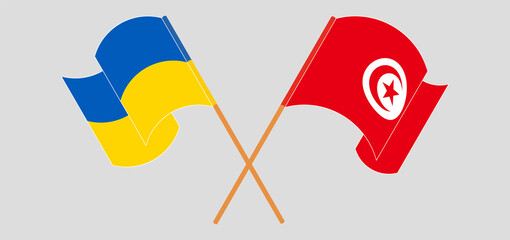 Crossed and waving flags of the Ukraine and Tunisia