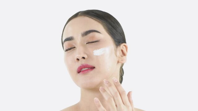 Beauty concept of 4k Resolution. Young Asian woman applying cream on her face.
