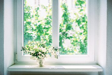 tree branches with white flowers in a vase with a face of apollo