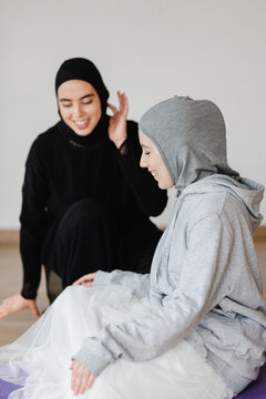 Muslim women stretching in studio together