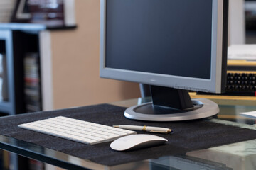 mesa de trabajo con un teclado , un raton y un monitor