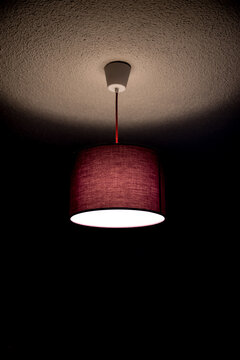 purple ceiling lamp lit in dark room
