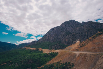 Roadworks in the foothills and a cloudy sky.