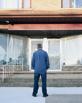 Man Looking at Empty Closed Store Building
