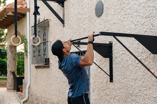 Active man training with sport equipment near house