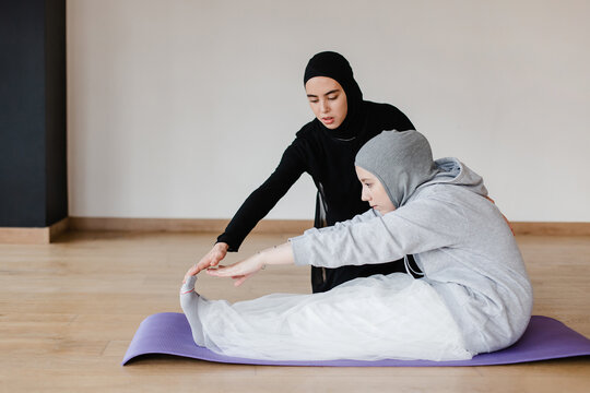 Muslim women stretching in studio together