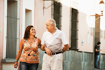 Hispanic father and daughter walking together in city