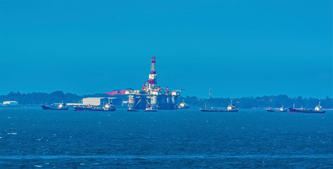Tankers moored close to oil rigs near Singapore in summertime