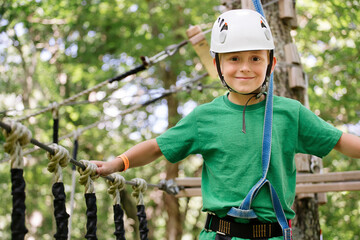 Caucasian boy balancing on rope bridge