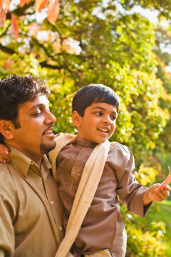 Indian father holding son