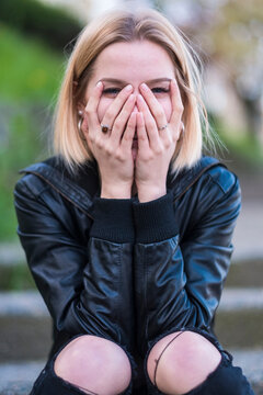 Laughing Caucasian woman covering face with hands