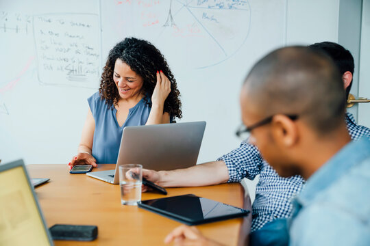 Business people using cell phones in meeting