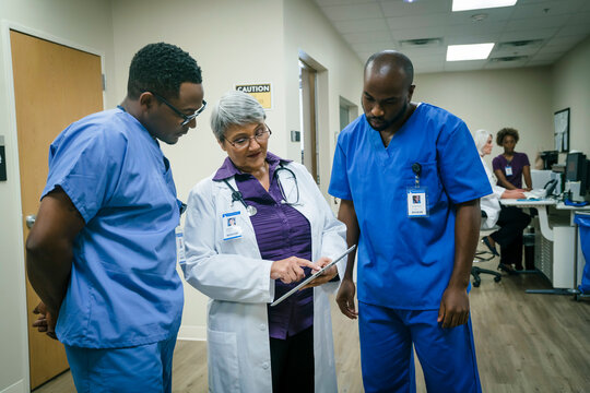Doctor and nurses discussing digital tablet