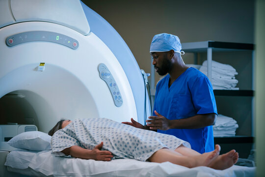 Technician talking to patient at scanner