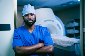 Portrait of confident black nurse near scanner
