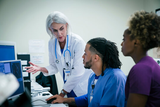 Doctor talking to nurses at computer