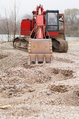 Gravel excavator by the river bank