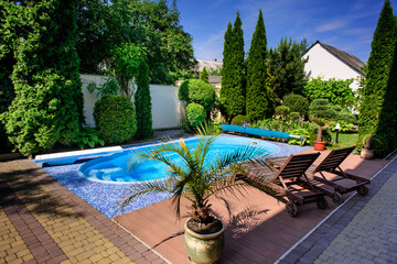 Wooden daybed place on tile floor near swimming pool.