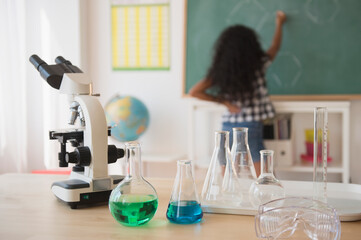 Mixed race student writing on chalkboard in classroom