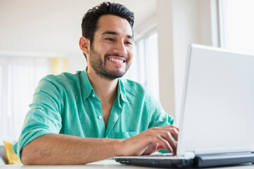 Mixed race man using laptop