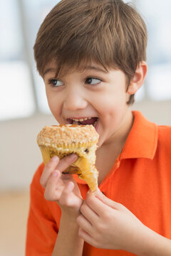 Hispanic boy eating muffin