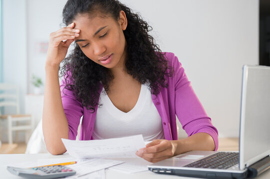 Mixed race woman paying bills online