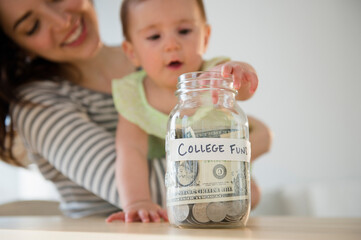 Mother and baby putting money in college fund