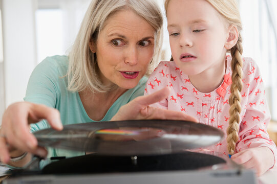 Senior Caucasian woman and granddaughter listening to records