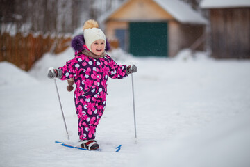 little baby girl skiing, laughing, winter, snow, snowdrifts, frost