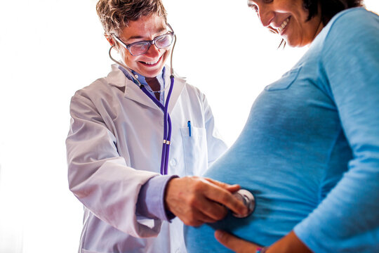 Doctor listening to woman√ïs pregnant belly