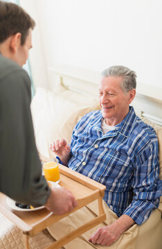 Senior Caucasian man having breakfast in bed