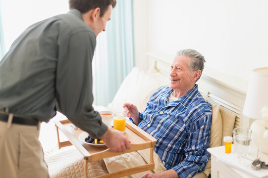 Senior Caucasian man having breakfast in bed