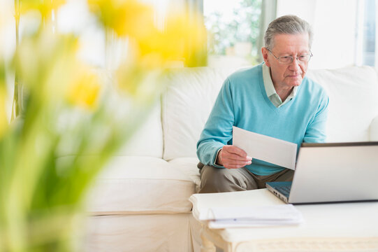 Senior Caucasian man paying bills online