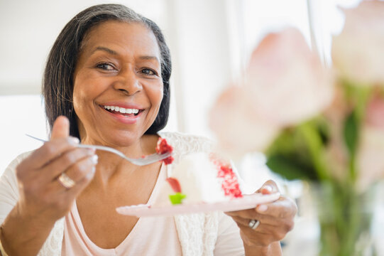 Mixed race woman sharing cake