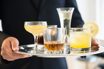 Close up of mixed race waiter holding tray of drinks