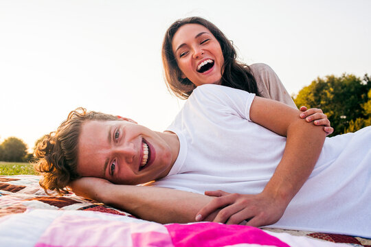 Caucasian couple relaxing on blankets in park