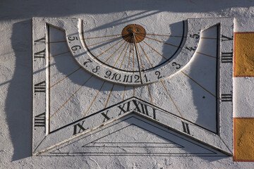 Sundial in the early morning at the Franciscan Klösterle monastery facade in the old town of Nördlingen, Germany