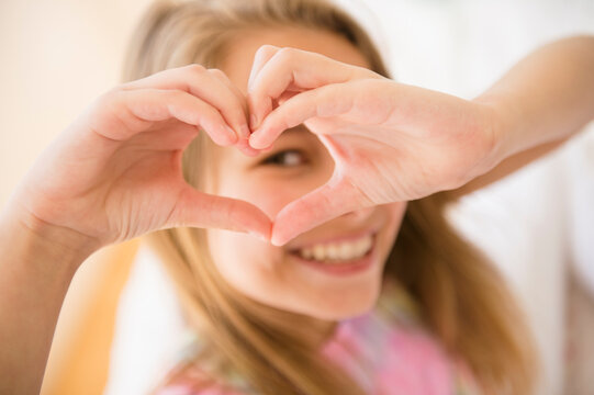 Caucasian girl making heart shape with hands