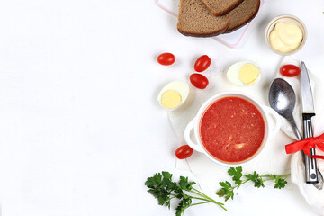Traditional Russian borsch with parsley and bread on a light table, business card for the menu, natural products and ingredients, healthy food concept, rustic style, selective approach.