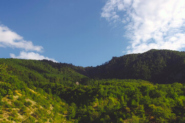 Obraz premium Wooded mountains and blue sky.