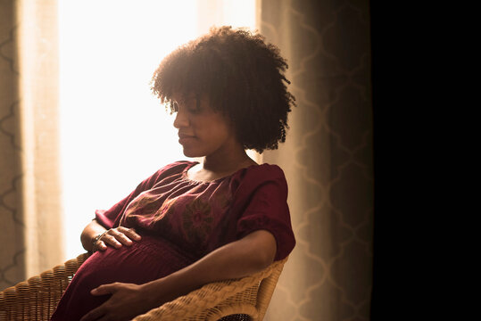 Pregnant African American mother holding her stomach