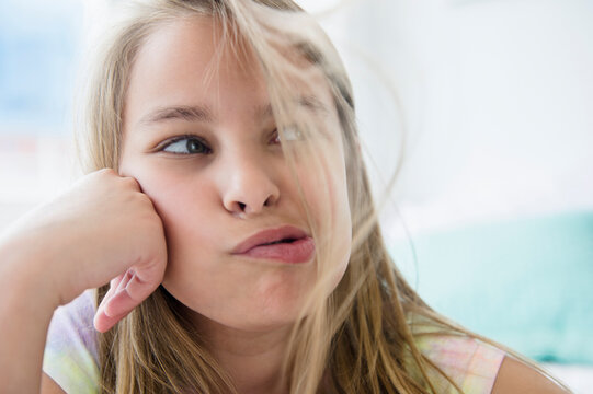 Caucasian girl blowing hair from her face