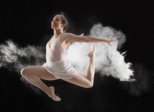 Hispanic dancer leaping in cloud