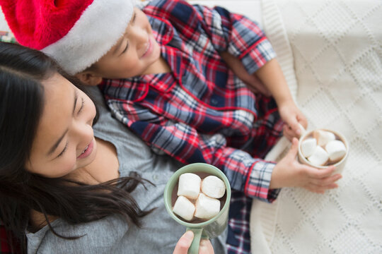 Asian brother and sister drinking hot cocoa at Christmas