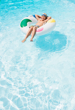 Caucasian boy floating in inflatable ring in swimming pool