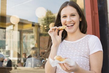 Caucasian woman eating outside cafe