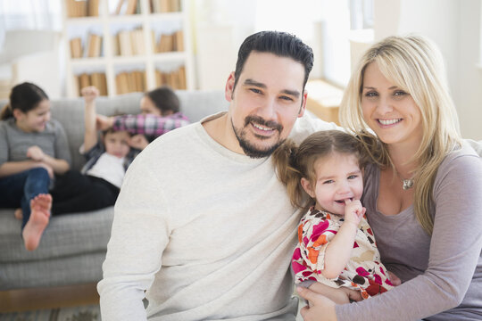 Caucasian parents and daughter smiling in living room