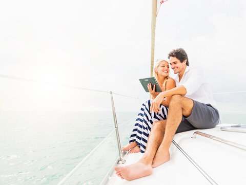 Couple using digital tablet boat deck