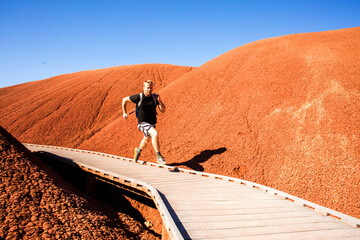 Caucasian man running on walkway in desert hills
