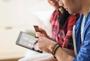 Close up of couple shopping online on digital tablet